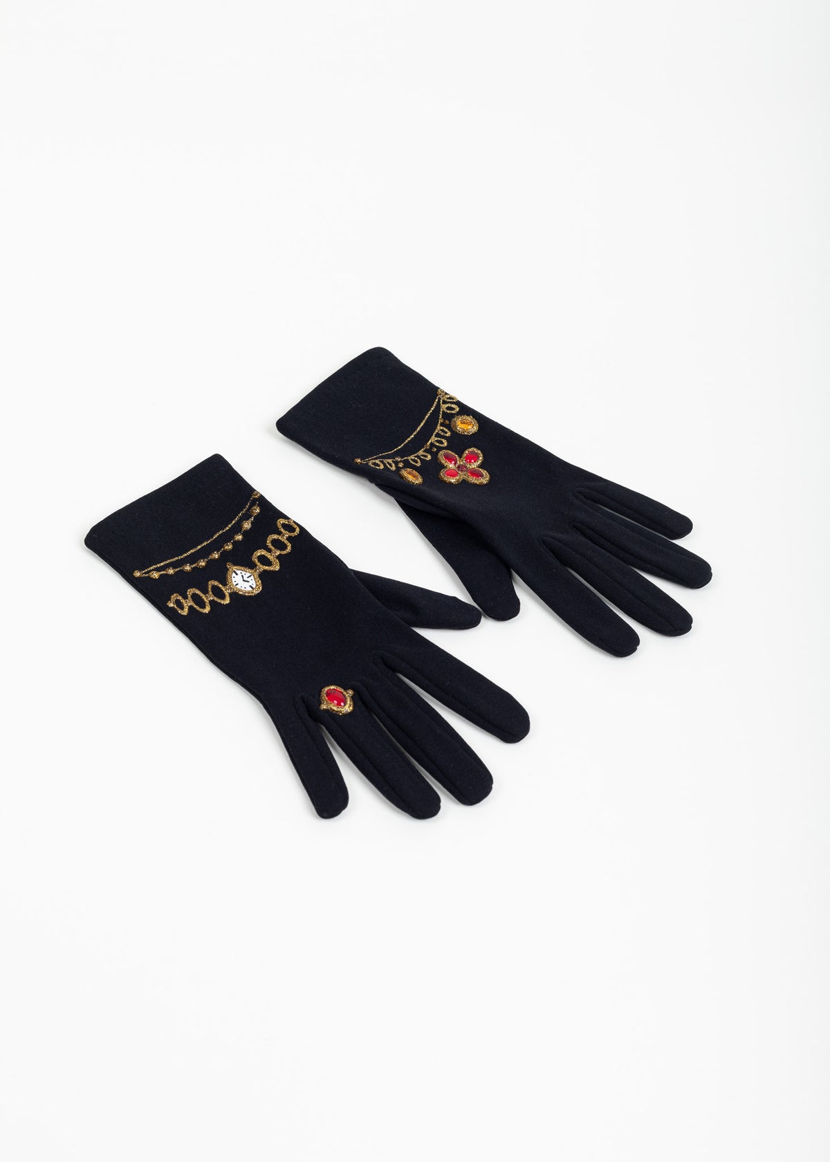 Pair of black evening gloves laid at an angle, backs showing painted gold watch, chains, red ring and red quatrefoil motifs