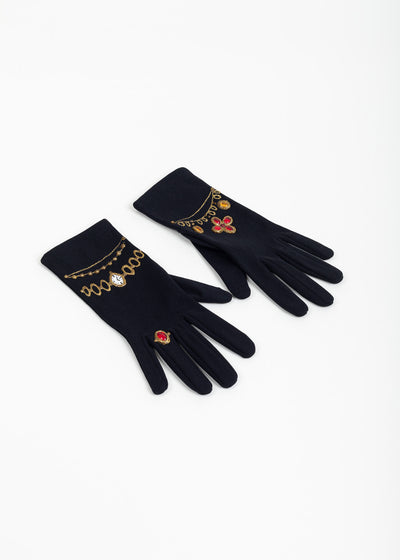 Pair of black evening gloves laid at an angle, backs showing painted gold watch, chains, red ring and red quatrefoil motifs