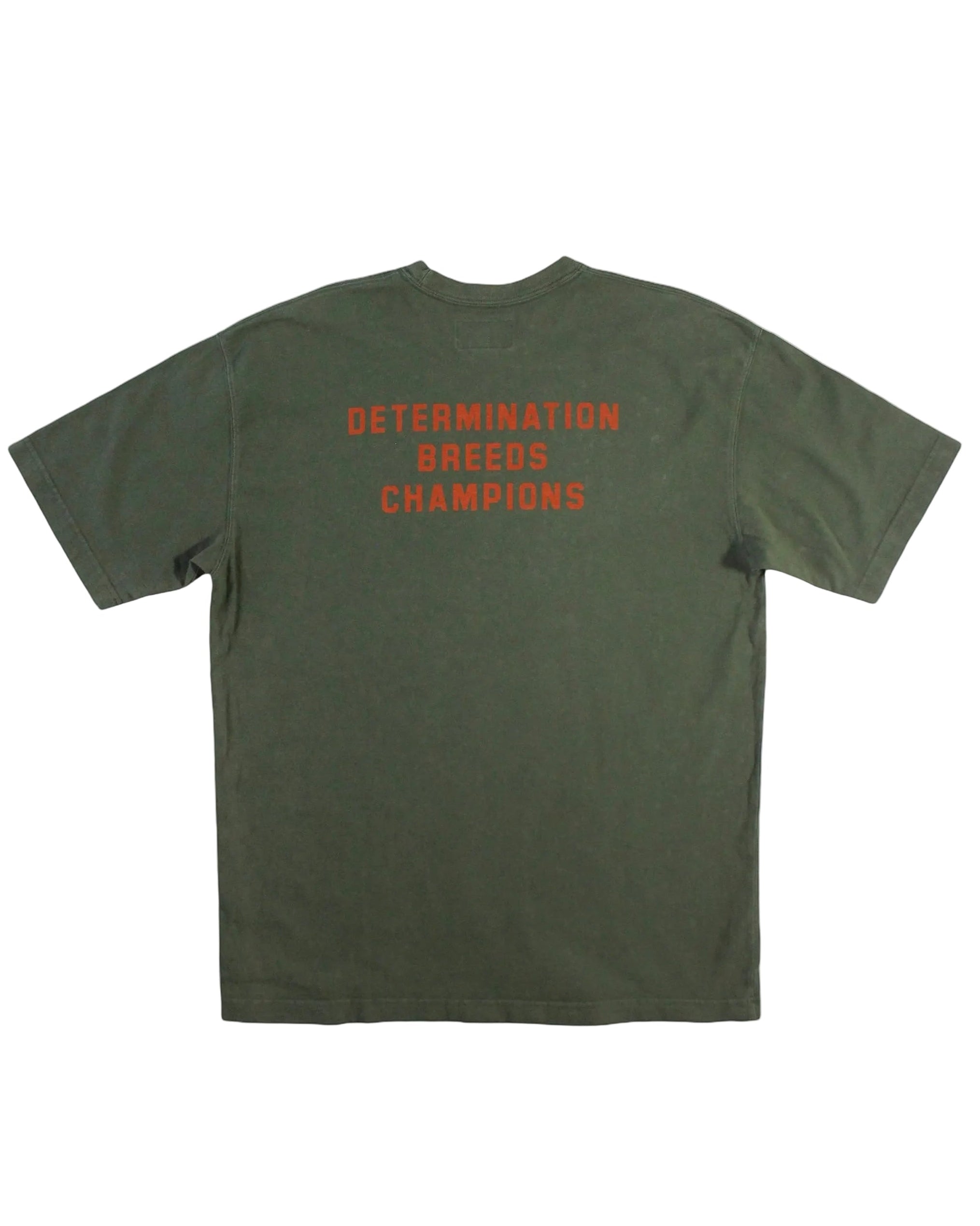 An olive green Abercrombie short-sleeve t-shirt with orange text on the chest reading 'DETERMINATION BREEDS CHAMPIONS', displayed flat against a white background.