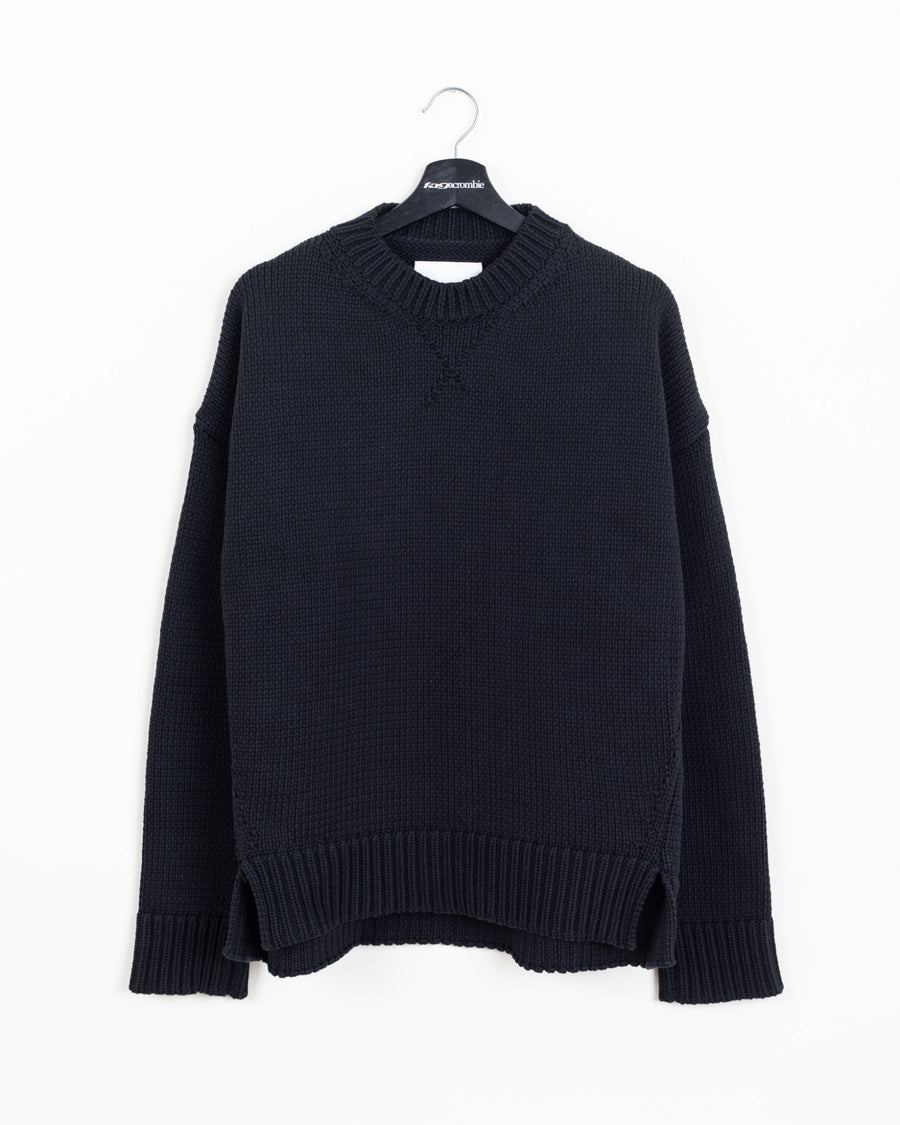Jil Sander black heavy-knit crewneck sweater, front view on hanger showing ribbed collar, side slits and stepped hem
