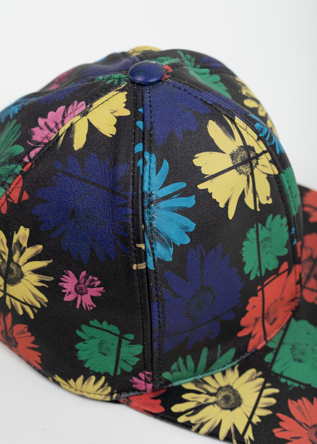 Close-up of the front panels and brim showing the daisy print and crosshair lines