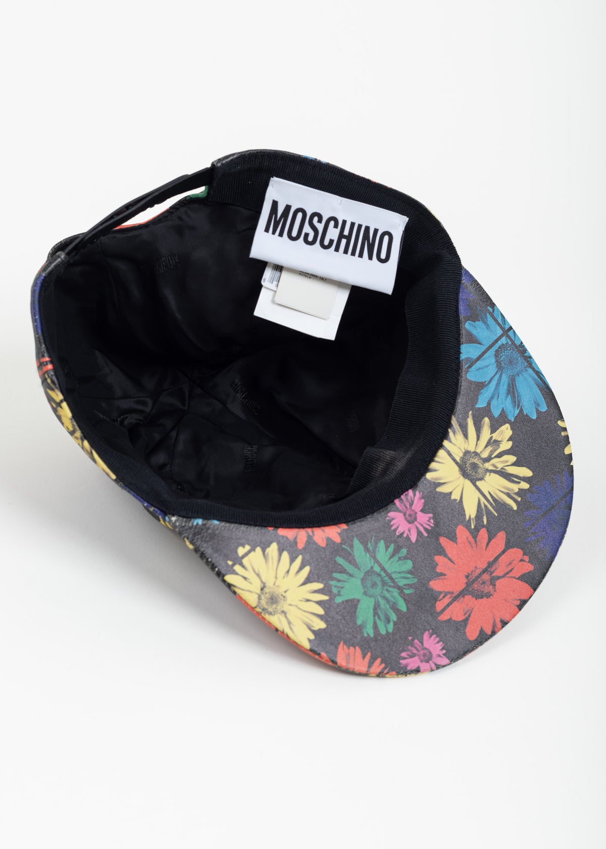 Underside of the cap showing the printed under-brim, tonal Moschino logo lining and Moschino label